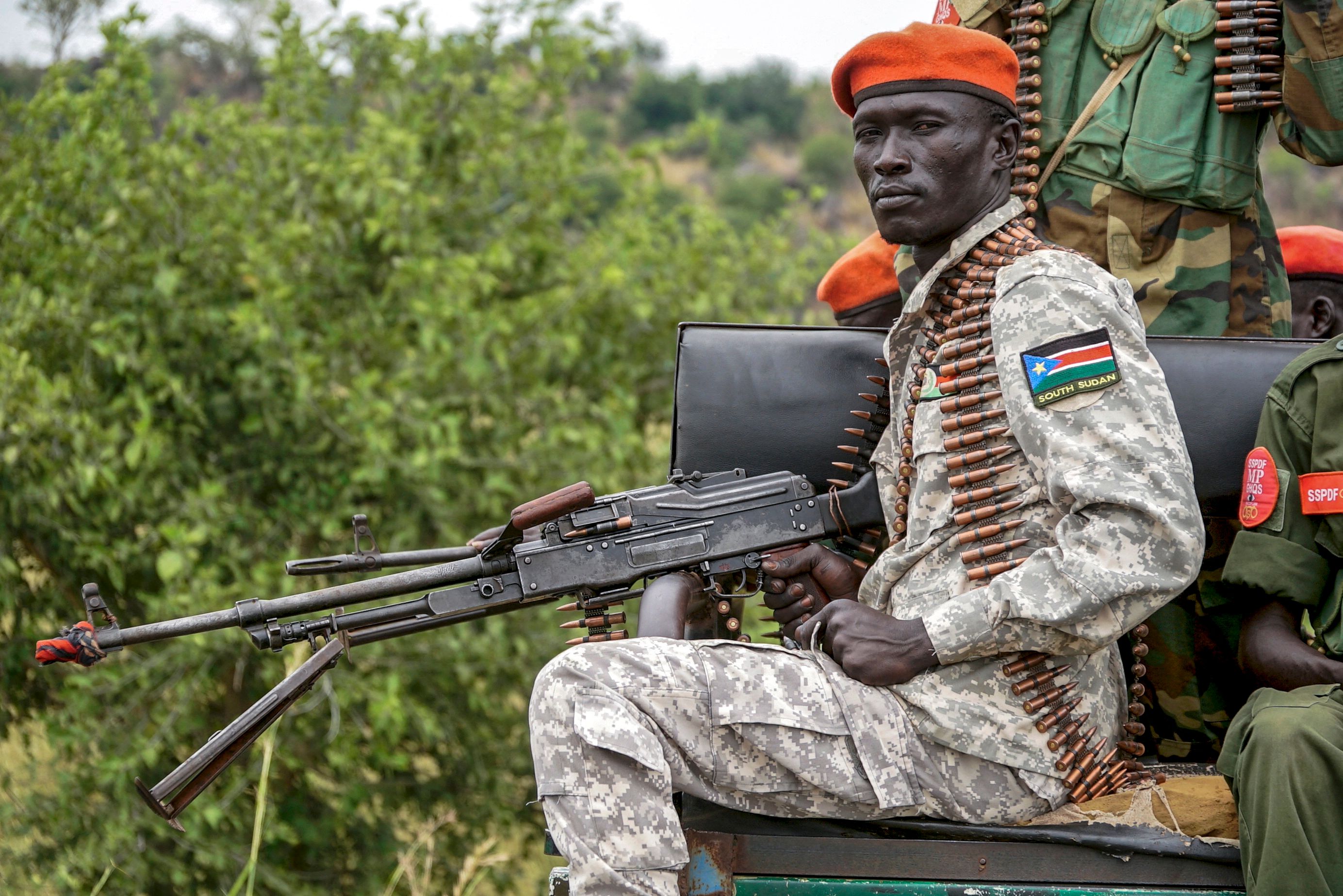 A South Sudanese military police officer sits on a pickup truck while monitoring the area as troops belonging to the South Sudanese Unified Forces take part in a deployment ceremony at the Luri Military Training Centre in Juba on November 15, 2023. Hundreds of former rebels and government troops in South Sudan's Unified Forces were deployed at a long-overdue ceremony on November 15, 2023, marking progress for the country's lumbering peace process. (Photo by Peter Louis GUME / AFP)